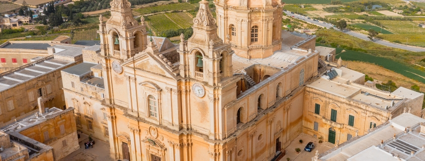 St. Paul's Cathedral in the town of Mdina surrounded by a fortress narrow streets, aerial view.